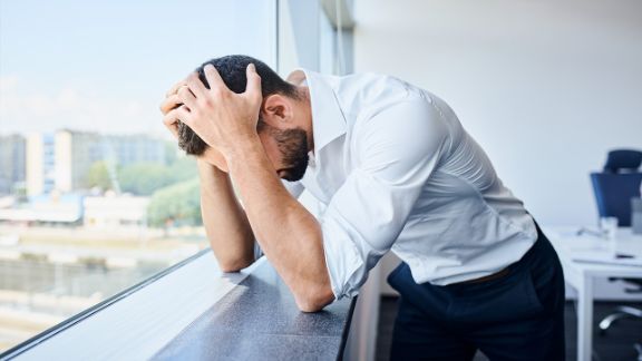 Ein Mann stützt gestresst den Kopf auf die Hände