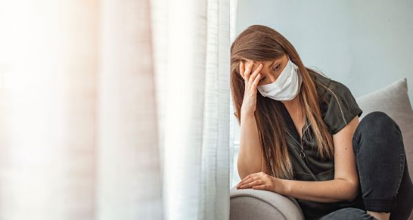 Hypochondrische Patientin in Panik Dame mit Atemmaske versteckt sich mit zugezogenen Vorhängen daheim