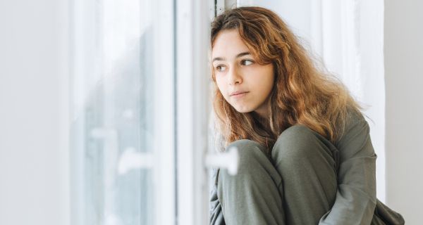 Teenagerin schaut aus dem Fenster