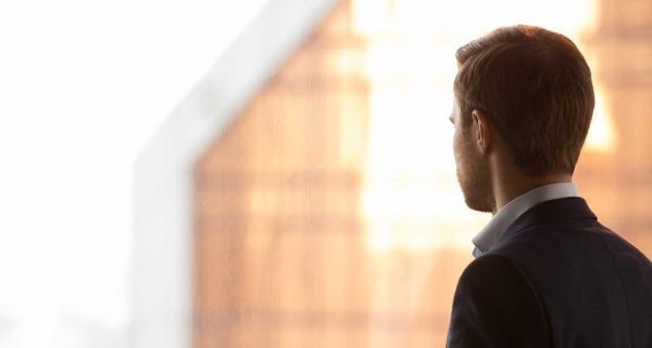 Nachdenklicher Geschäftsmann schaut aus dem Fenster Interview mit Professor Stephan Ahrens vom Fachzentrum Falkenried zum Begriff Work-Life-Balance im Zusammenhang mit Stress