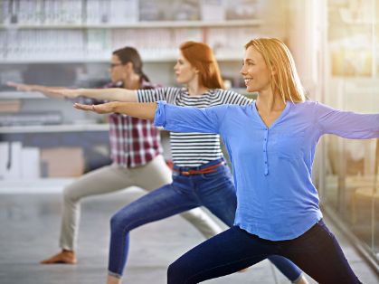 Bild: Frauen in Bürokleidung machen Yoga
