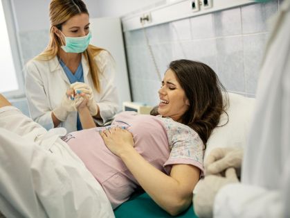 Bild: Hebamme mit schwangerer Frau bei der Geburt