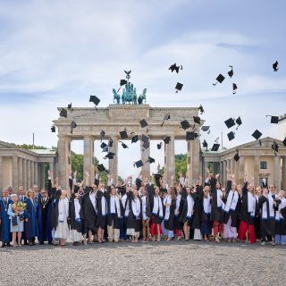 Der traditionelle Hutwurf vor dem Brandenburger Tor bildet den feierlichen Abschluss der Diplomverleihung.