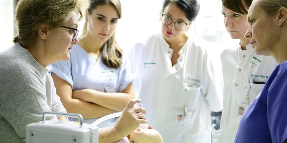 Bild: Teilnehmer beatmen die Neugeborenen Simulationspuppe