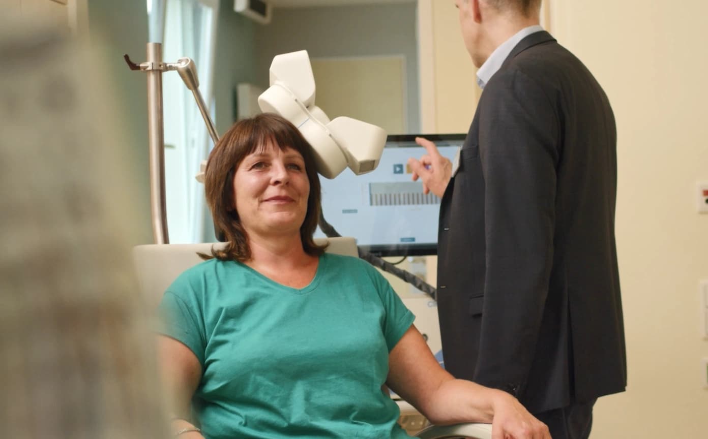 Das Bild zeigt eine Patient:in bei der rTMS Therapie