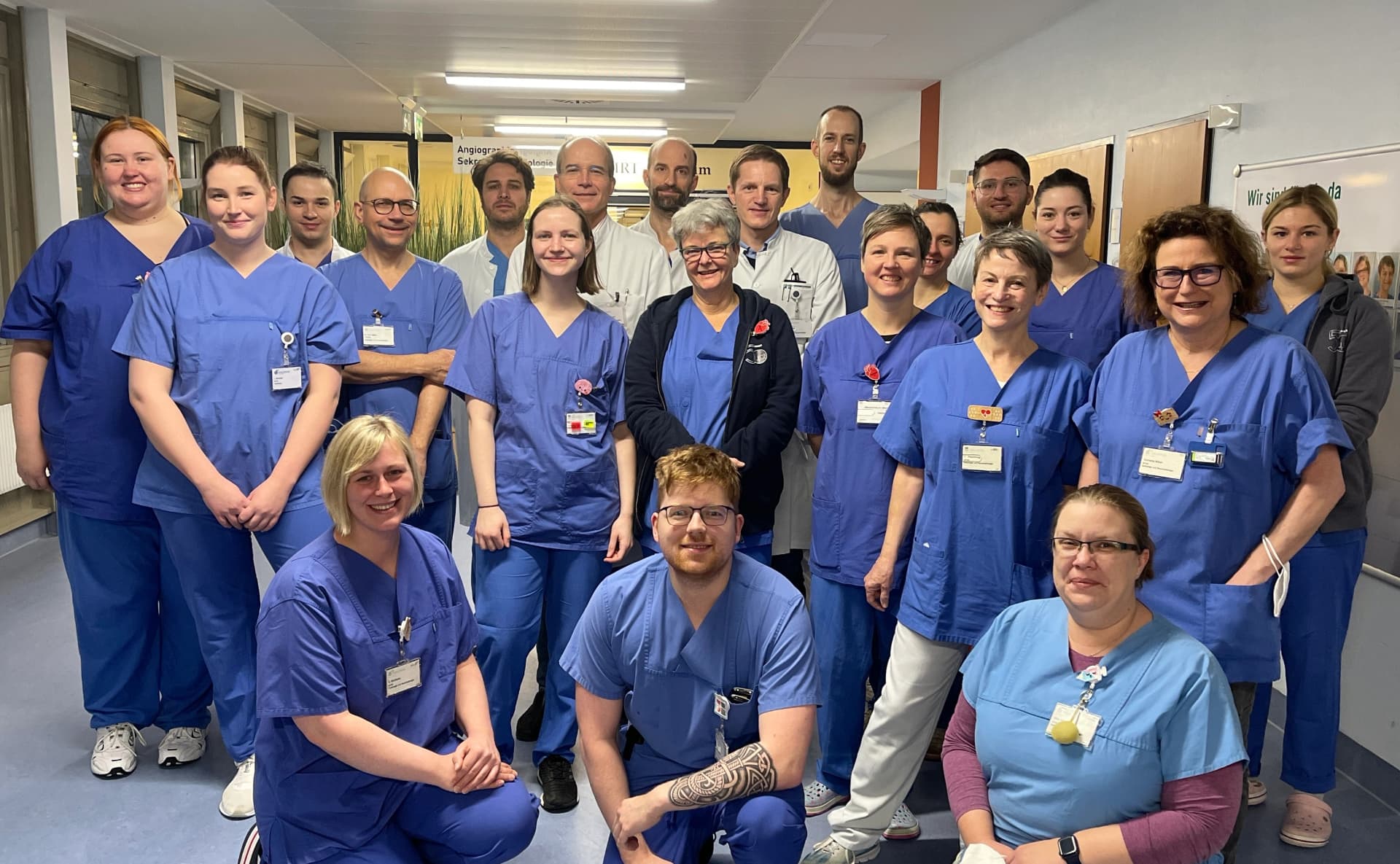 Teamfoto von vielen Kolleg:innen. Alle tragen blaue Dienstkleidung udn freuen sich auf Bewerbungen.