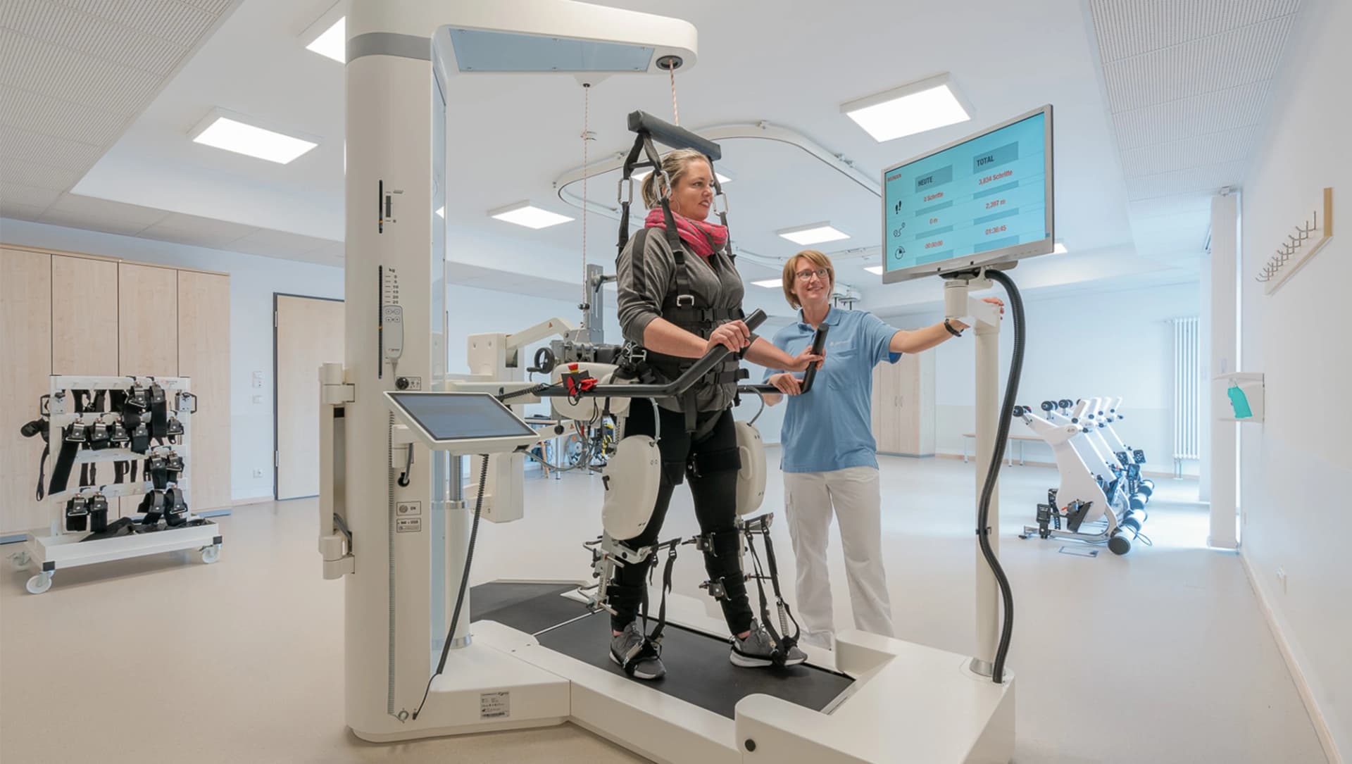 Eine Patientin ist im Gangroboter und bekommt Hilfestellungen durch die Therapeutin