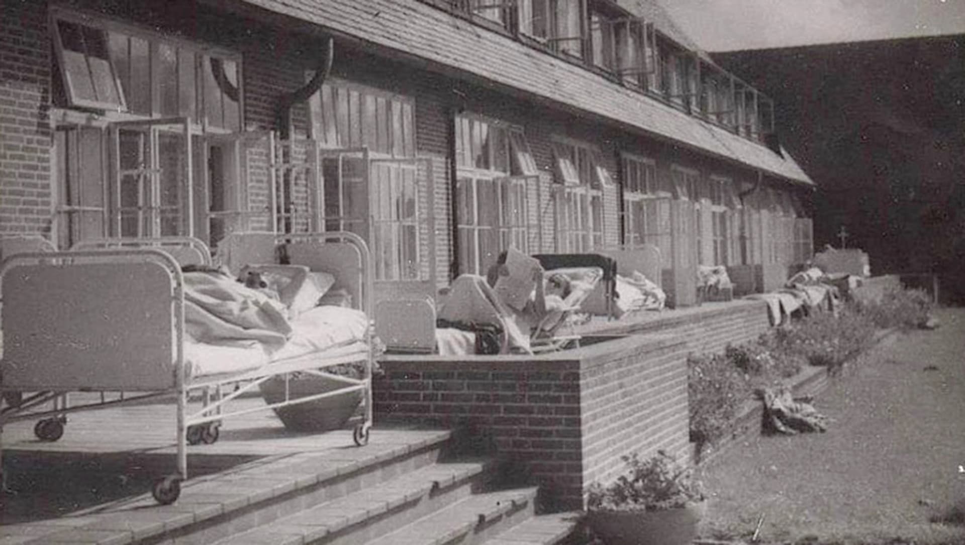 Historische Aufnahme zeigt Patienten auf der Liegeterrasse der Chirurgischen Abteilung
