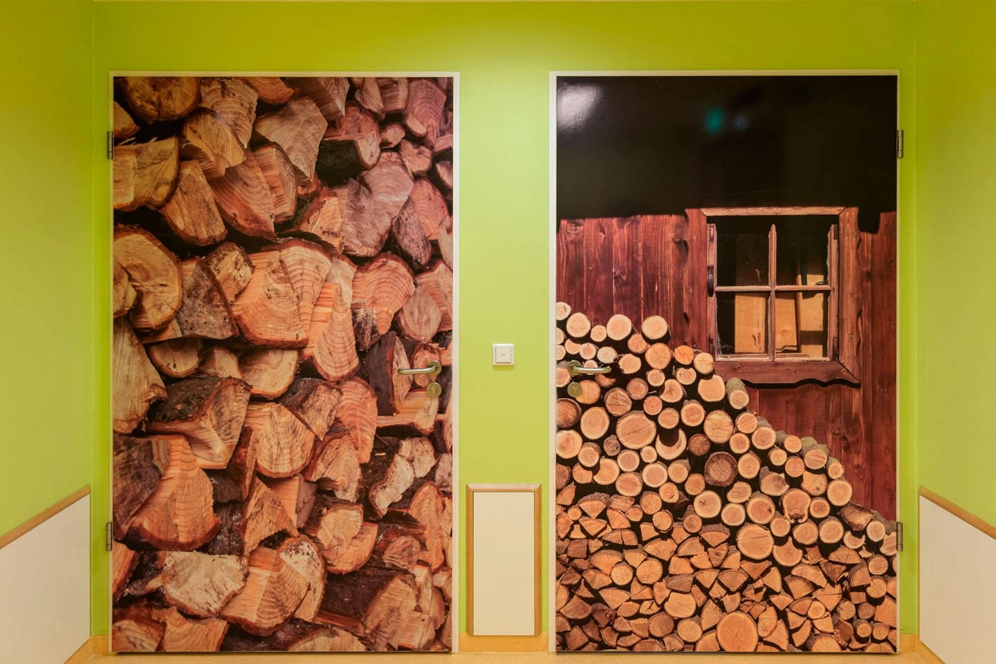 Das Bild zeigt 2 Kliniktüren. Auf der Linken Tür ist gestapeltes Holz abgebildet, auf der rechten Tür gestapeltes Holz vor einem Holzhaus.