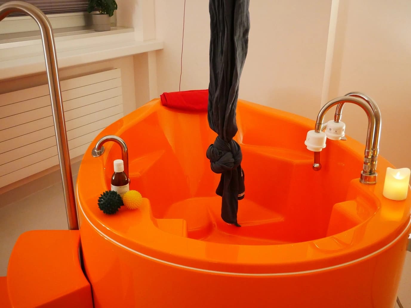 Das Motiv zeigt eine orangefarbene Entbindungswanne für eine Wassergeburt.