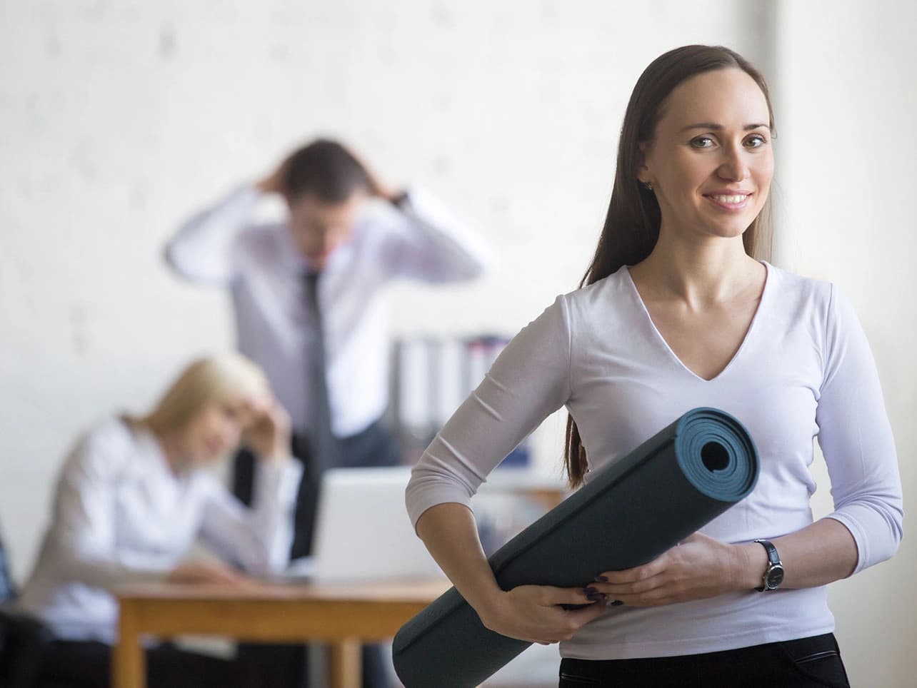 Bild: Frau mit Yogamatte im Büro
