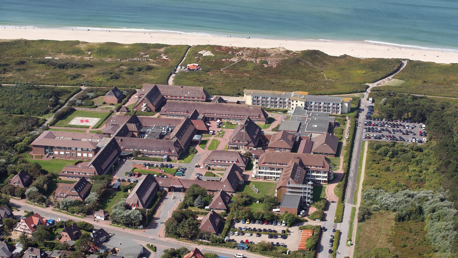 Das Motiv zeigt ein Luftbild der Asklepios Nordseeklinik mit der Nordsee im Hintergrund.