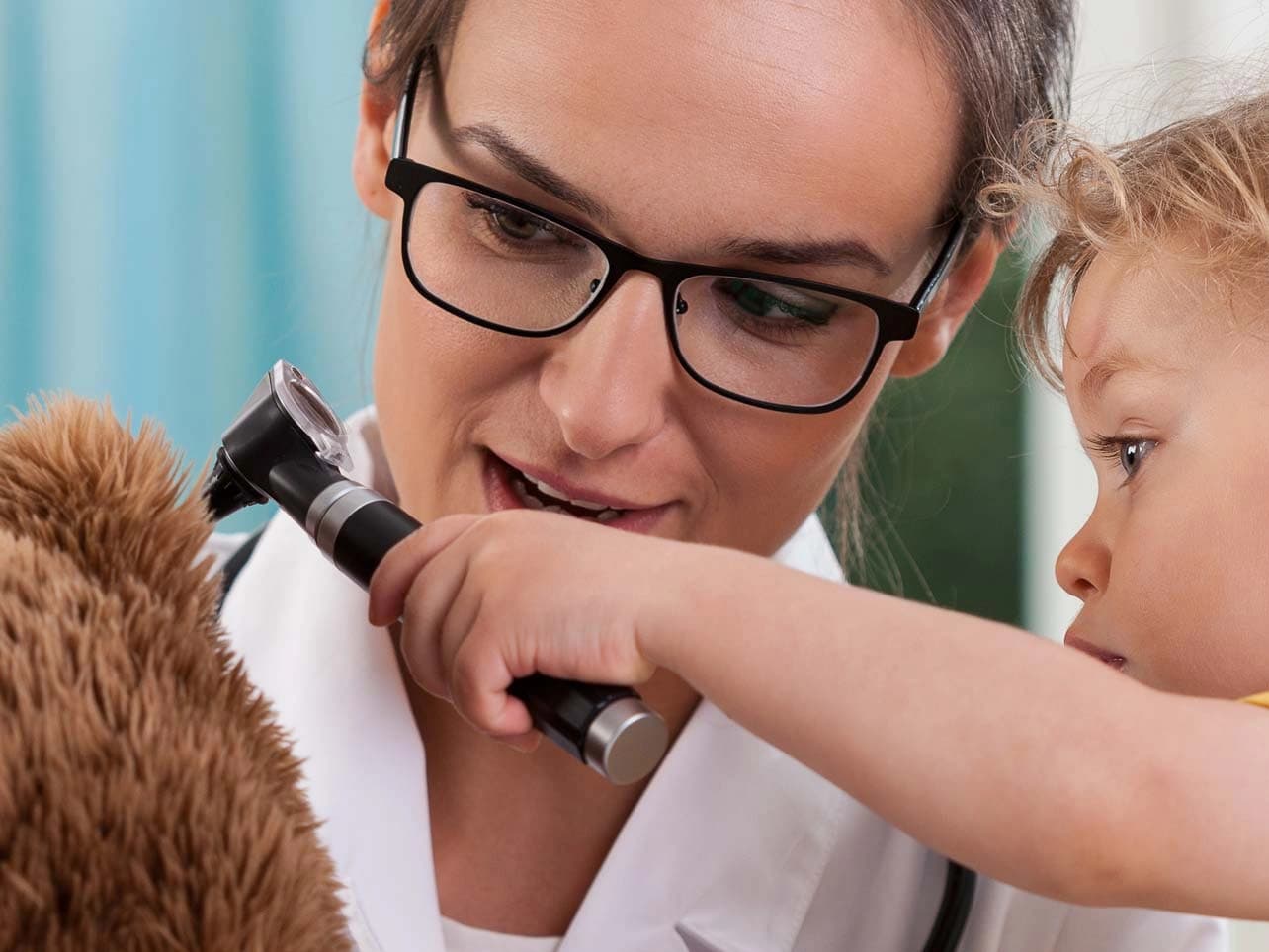 Bild: Ärztin mit Kleinkind und Stoffbär