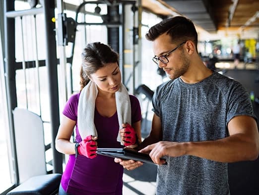 Bild: Frau mit Trainer bei der Trainingsplanerstellung