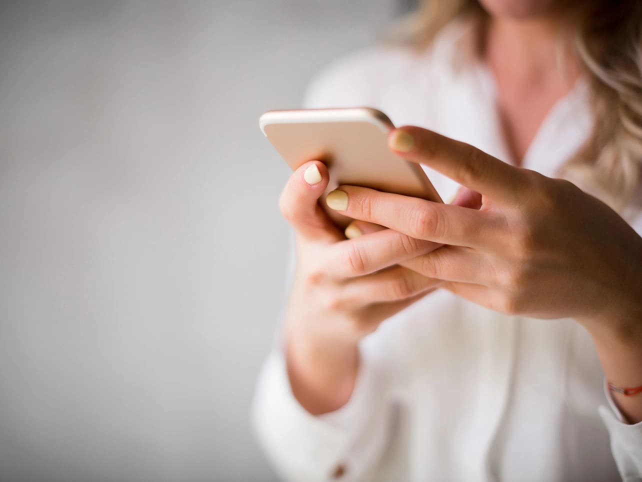 Bild: Frau bucht Online-Termin mit dem Smartphone