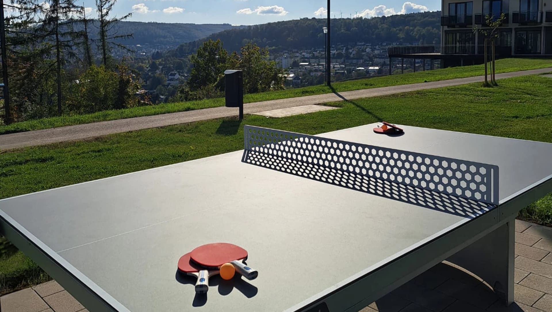 Tischtennisplatte mit Schlägern im Außenbereich