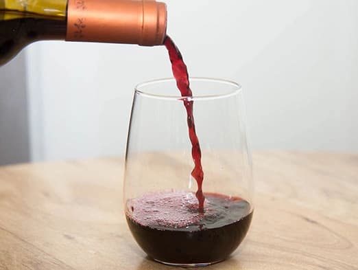 Bild: Glas Rotwein wird eingegossen