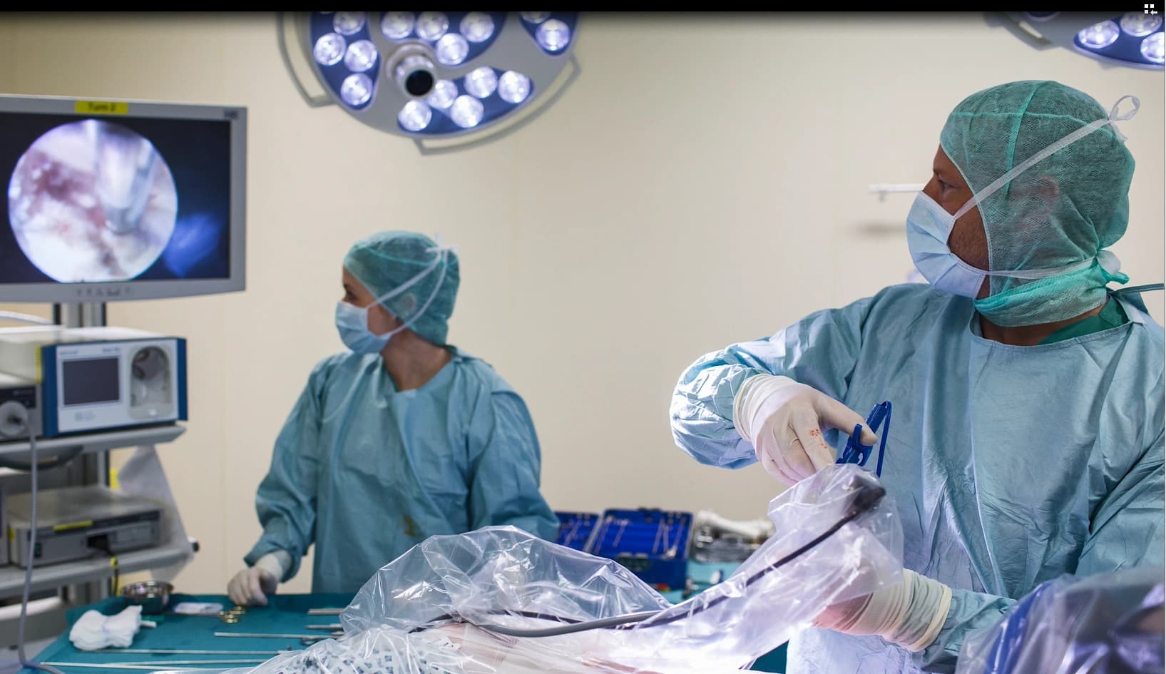 Das Motiv zeigt zwei Ärzte bei einer endoskopischen Operation im OP Saal.