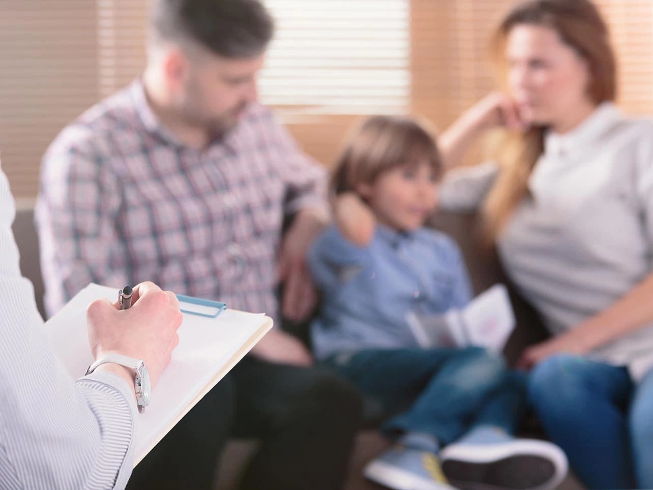 Bild: Eltern mit Kind bei der Therapie