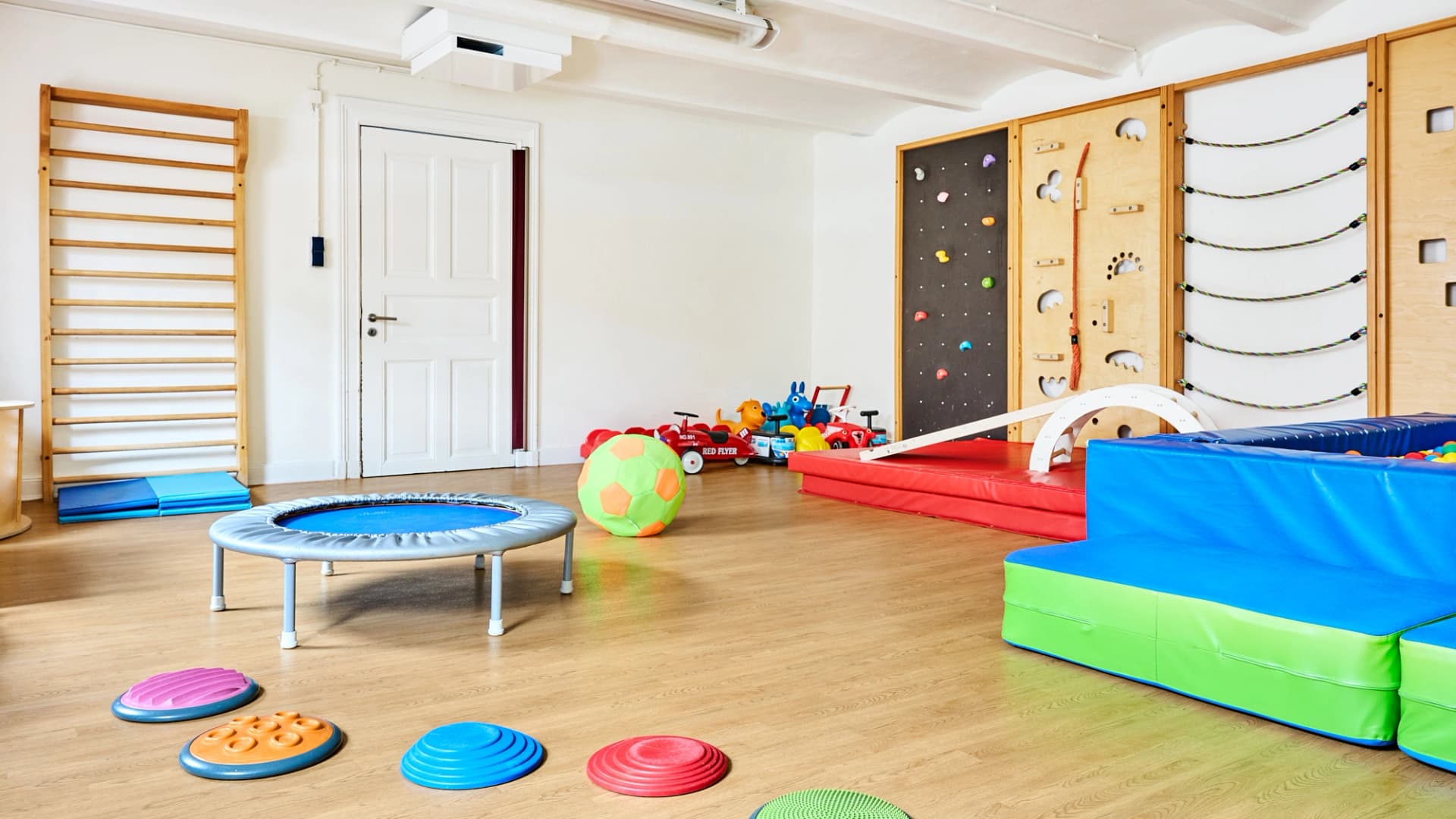 Bild: Bewegungsraum mit Kletterwand, Matten und Trampolin