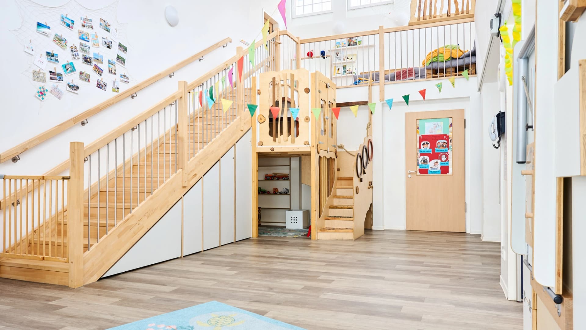 Bild: Zentraler Erschließungsbereich der Kita Rübennasen mit Treppenanlage, Galerie und zusätzlichen Spielbereichen.