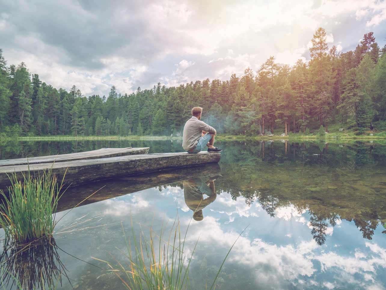 Bild: Mann am See entspann auf einem Steg
