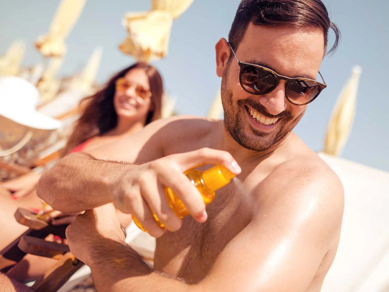 Bild: Paar am Strand cremt sich ein