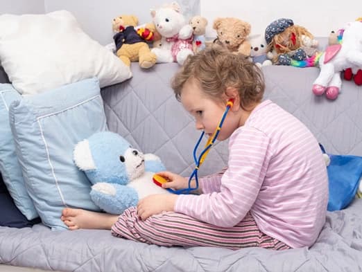 Bild: Kind spielt Arztbesuch mit Teddy nach