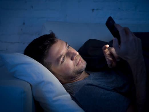 Bild: Mann im Bett am Handy