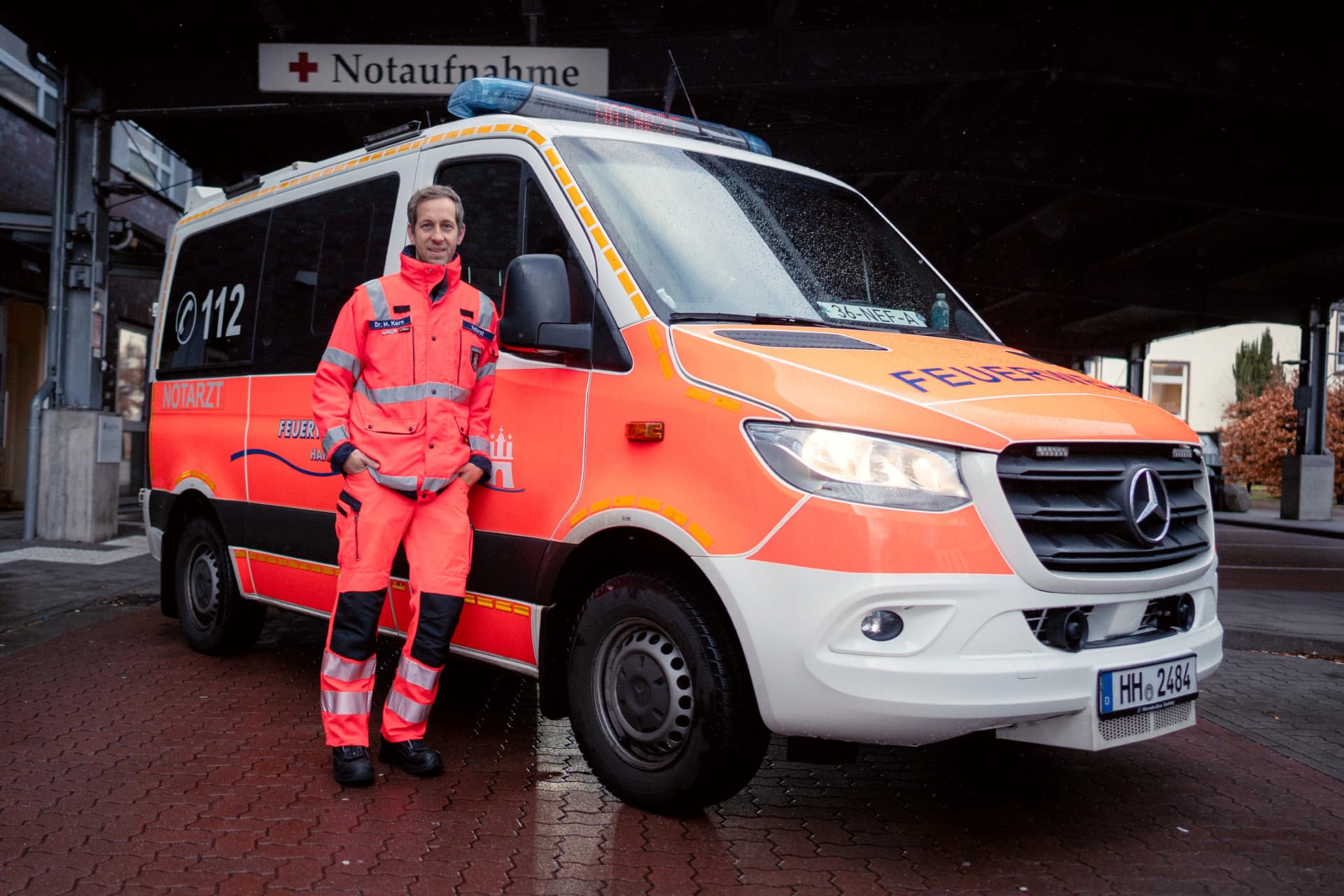 Foto: Sanitäter angelehnt an Rettungswagen