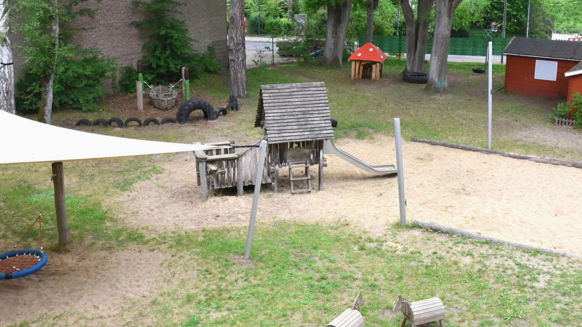 Bild: Kita-Außengelände mit Spielhaus, Sandkasten und Schaukel