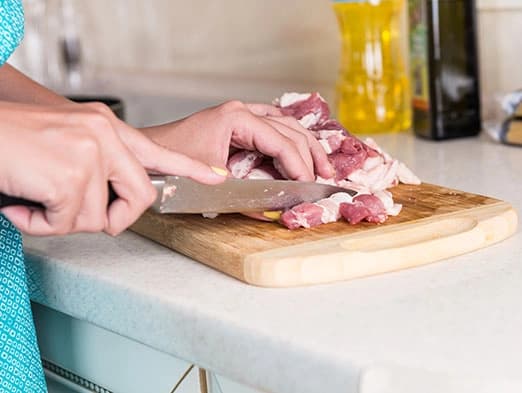 Bild: Schneiden von Fleisch auf einem Holzbrett