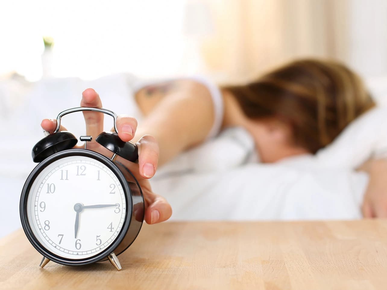 Bild: Frau im Bett mit Wecker