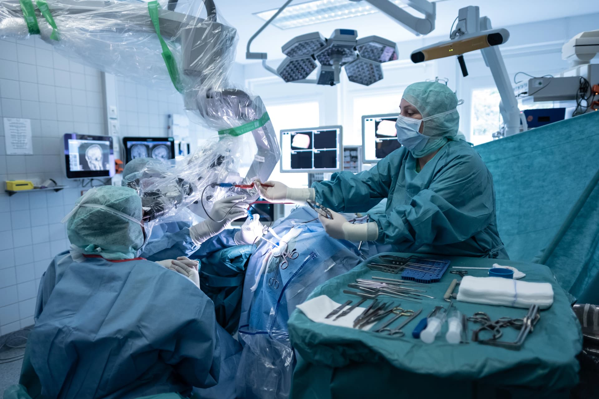 Das Bild zeigt den Operationssaal der Neurochirurgie. Eine OTA assistiert dem Chirurgen.