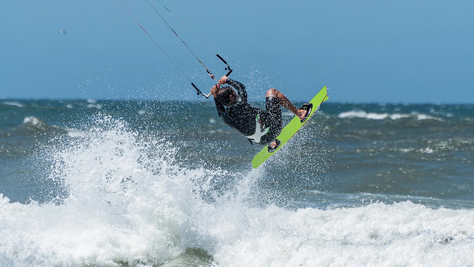 Das Motiv zeigt einen Kitesurfer im Meer.