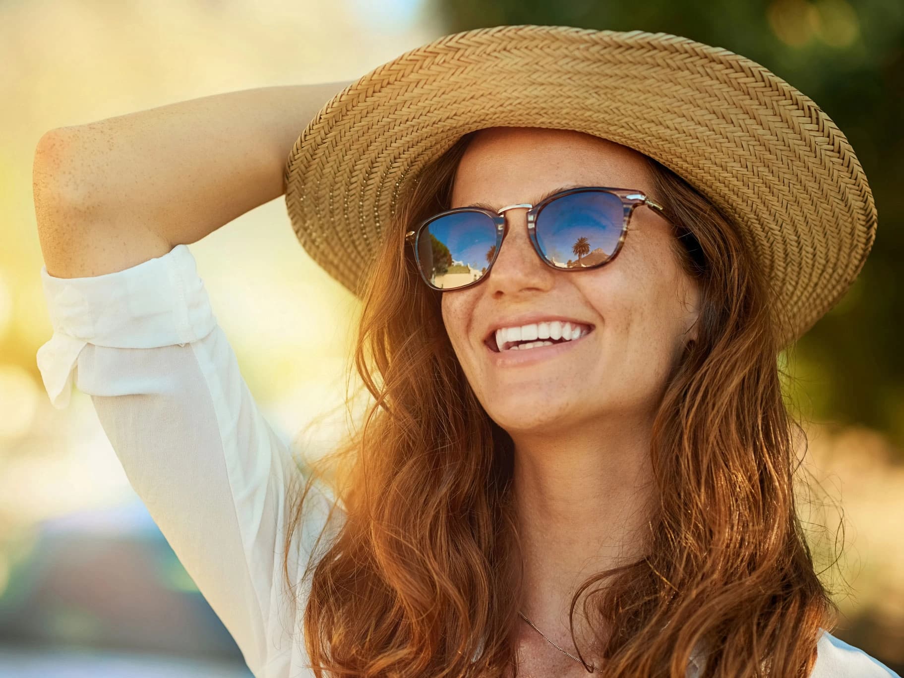 Bild: Frau mit Sonnenbrille und Strohhut