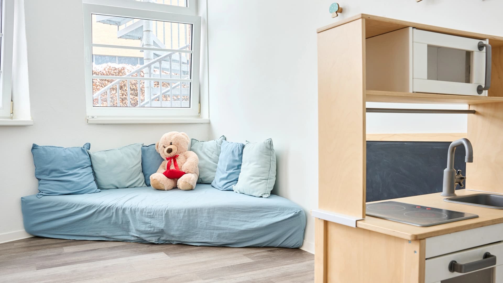Bild: Gemütliche Rückzugsecke mit Sofa und Spielküche in der Asklepios Kita Rübennasen.