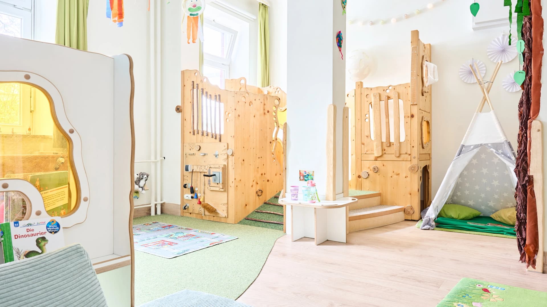 Bild: Halbgeschlossene Rückzugsnische mit weichen Elementen für ruhiges Spiel und Entspannung.