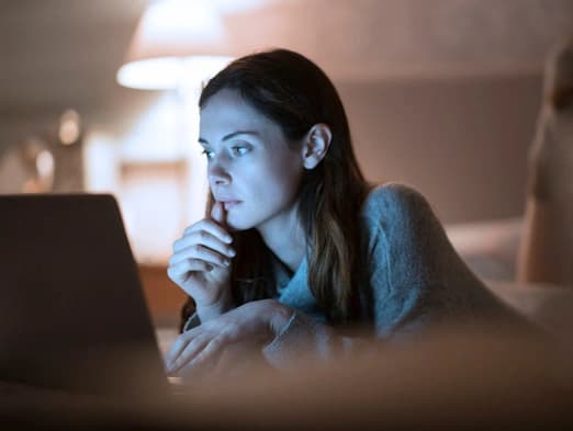 Bild: Frau mit Laptop im Bett