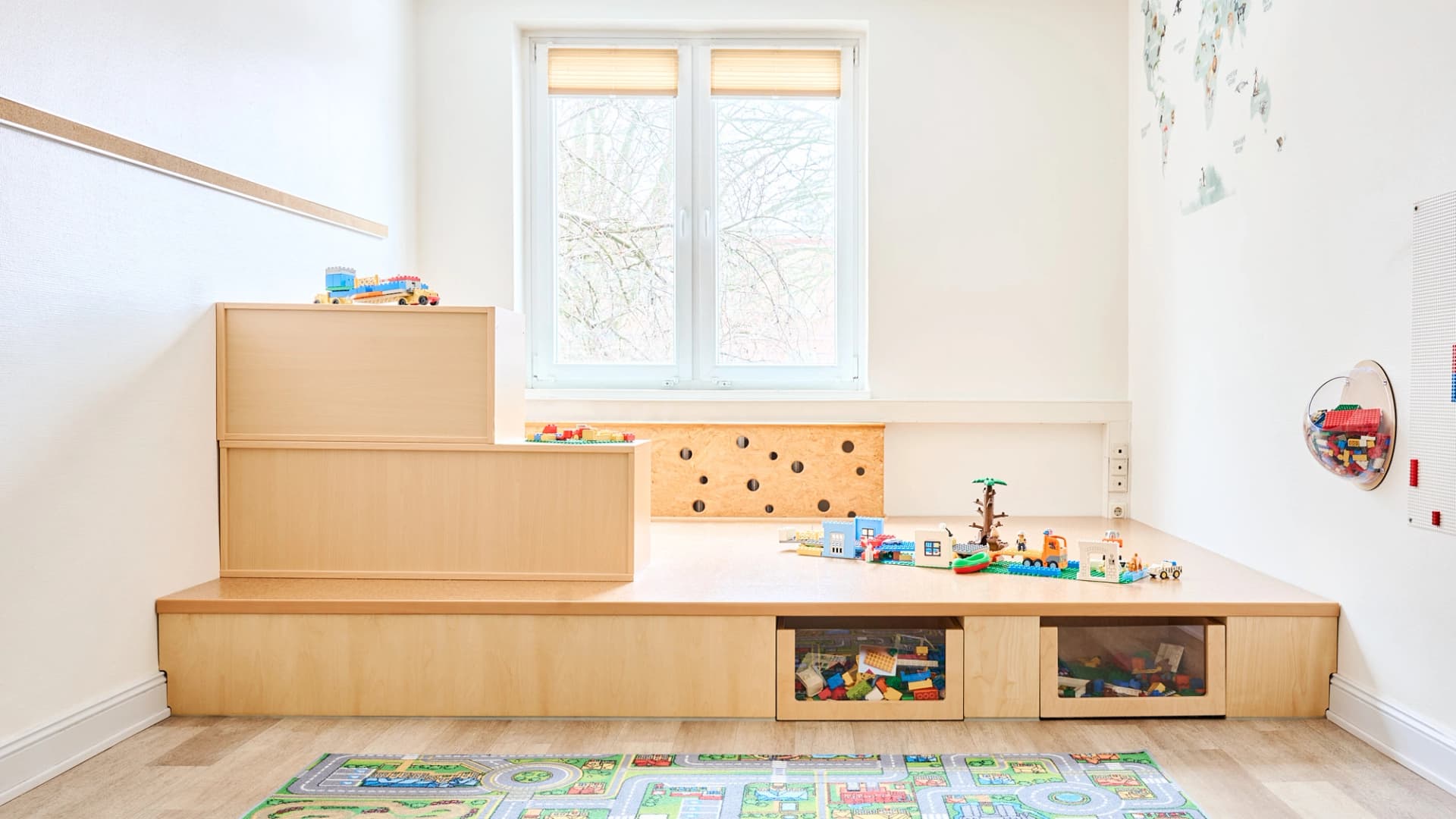 Bild: Spielpodest aus Holz mit freier Bodenfläche zum Spielen, Gestalten und kreativen Ausprobieren.