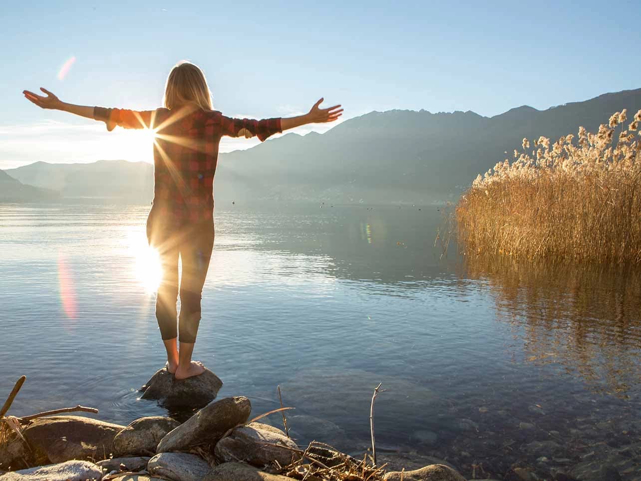Bild: Frau in entspannter Haltung am See