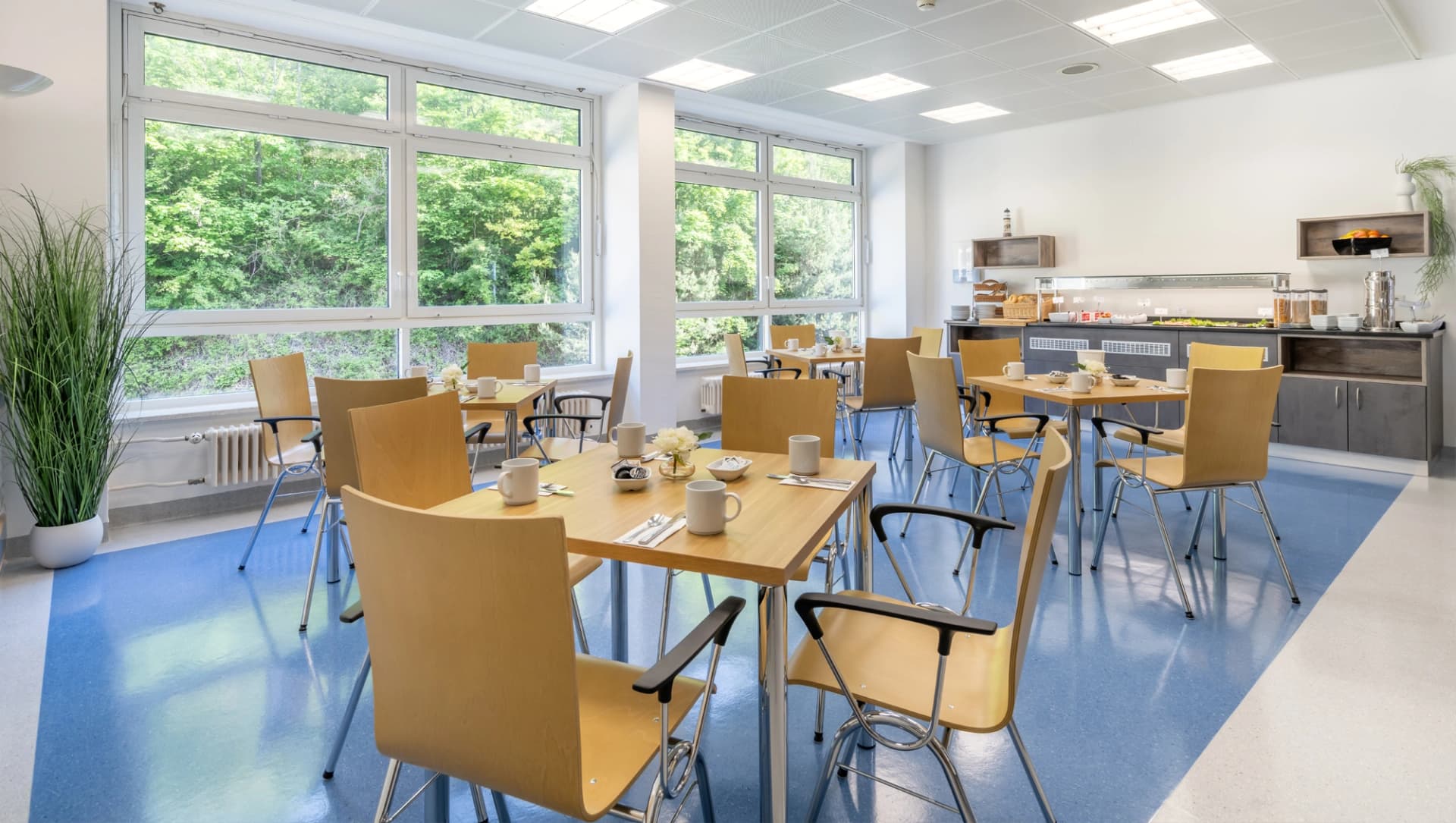 Es sind die Sitzgruppen im Speisesaal zu erkennen vor dem Buffet