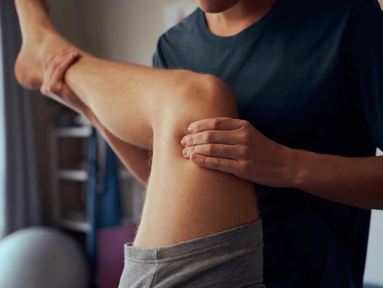 Bild: Physiotherapeut behandelt Sportler:in
