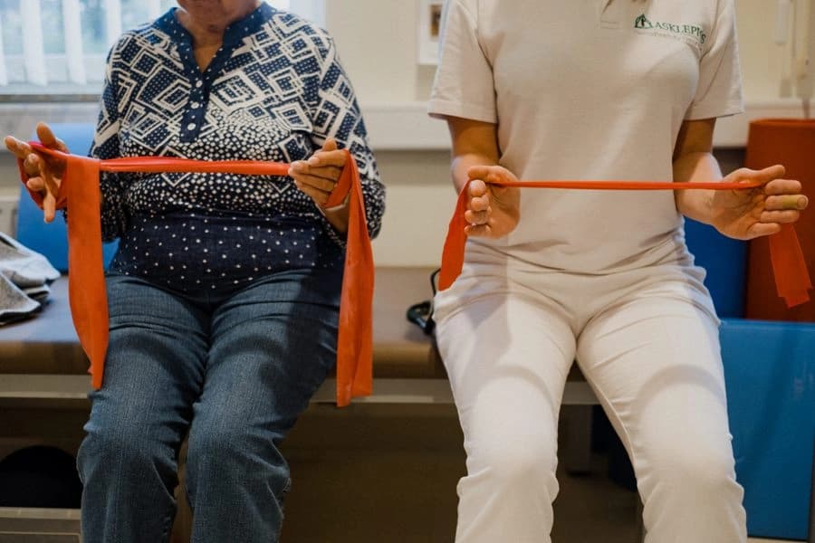 Bild: Therapeutin und Patient mit Bewegungsband