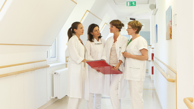 Kolleginnen bei einer Besprechung Mitarbeiterinnen auf dem Patientenflur