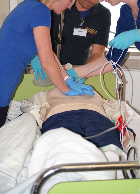 Reanimation im Bett Medizinisches Personal reanimiert eine Puppe im Bett