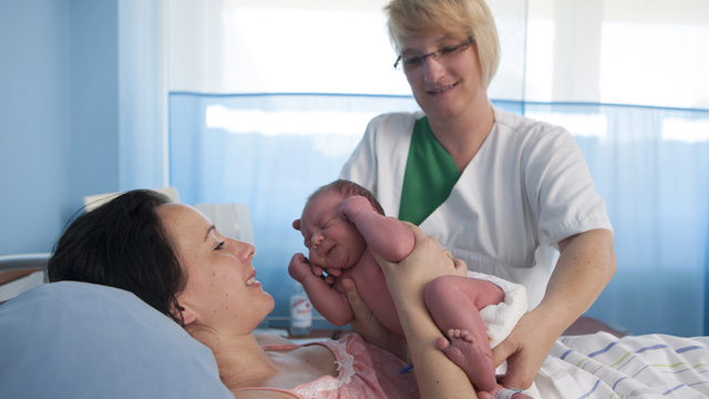 Mama mit ihrem Baby und einer Pflegerin Neugeborenes mit Mutter