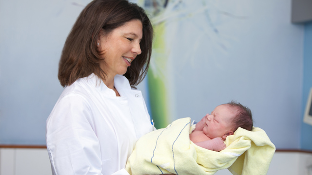 Dr. Stefanie Buchen hält Baby auf dem Arm Baby schläft in den Armen einer Ärztin