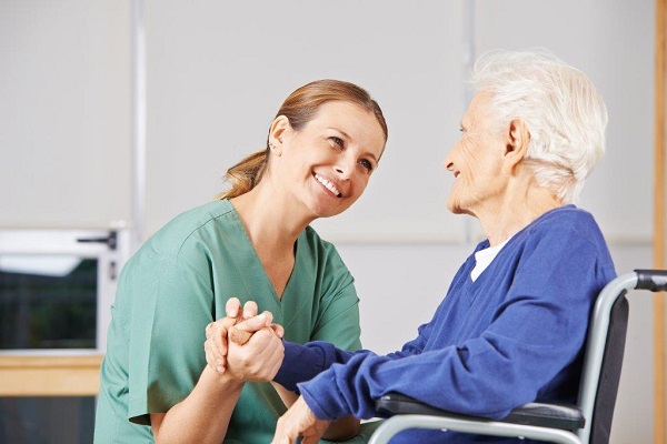 Pflegerin mit Patientin im Rollstuhl Pflegerin mit Patientin im Rollstuhl