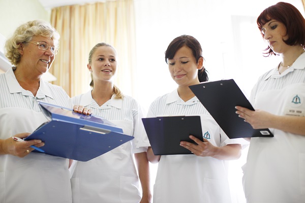 Vier Schwestern vor Patientenbett Übergabe am Bett